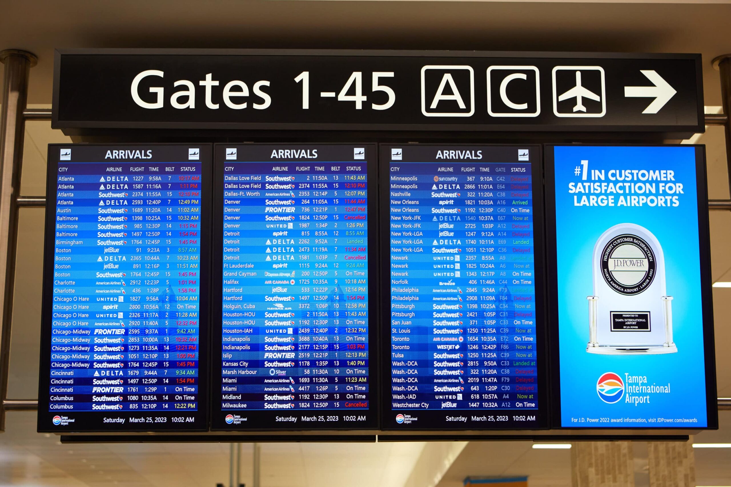 Airport departures display shows airlines, flight numbers, cities, and times. Tampa Airports customer satisfaction sign visible.